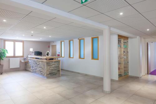 an office with a lobby with white walls and a pillar at Hotel Spa Les Rives Sauvages in Malbuisson