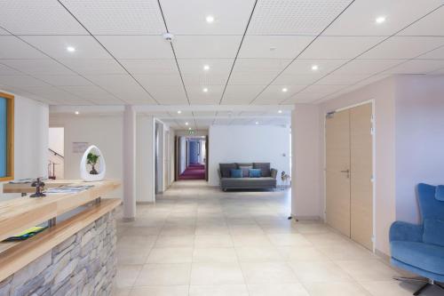 an office lobby with blue chairs and a couch at Hotel Spa Les Rives Sauvages in Malbuisson