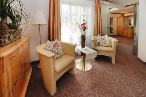 a living room with two chairs and a table at Hotel Krone in Schruns-Tschagguns
