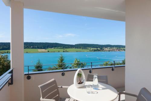 a dining room with a view of the water at Hotel Spa Les Rives Sauvages in Malbuisson