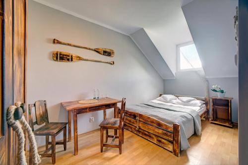 a bedroom with a bed and a table with a table sidx sidx at Pensjonat Reda in Polańczyk