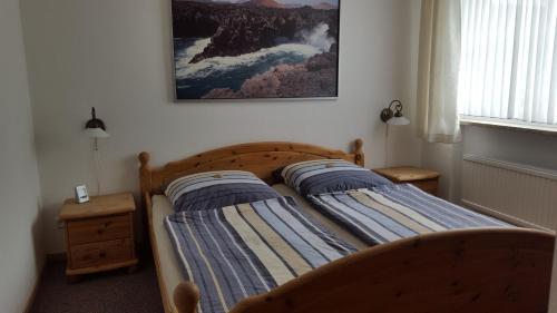 twee bedden in een slaapkamer met een foto aan de muur bij Ferienwohnung Weiser in Cuxhaven