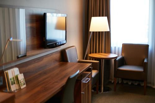 a hotel room with a tv and a table and chairs at Holiday Inn Krakow City Centre, an IHG Hotel in Krakow