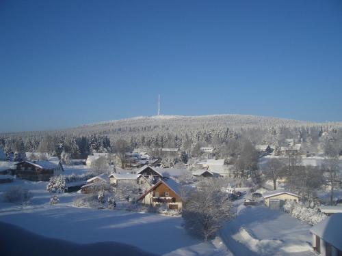 a town covered in snow with a mountain in the background at Hotel Bergblick in Warmensteinach