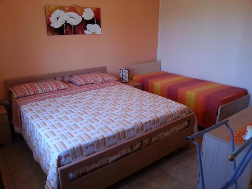 ボルガニェにあるCasette nel Borgoのベッドルーム1室(ベッド2台付)が備わります。壁には絵画が飾られています。