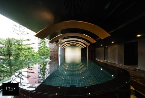 a swimming pool in a building with a ceiling at STAY Hotel BKK - SHA PLUS in Bangkok
