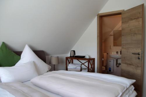 1 Schlafzimmer mit einem weißen Bett und einem Badezimmer in der Unterkunft Gästezimmer Gier in Dahlem