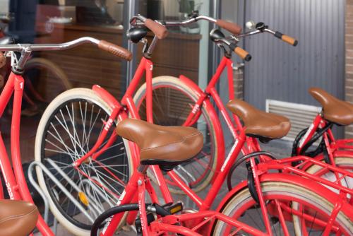 a group of red bikes parked next to each other at Htel Serviced Apartments Amstelveen in Amstelveen
