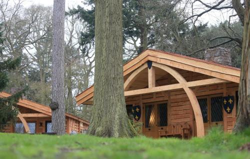 uma cabana de madeira na floresta com duas árvores em Warwick Castle Hotel & Knight's Village em Warwick