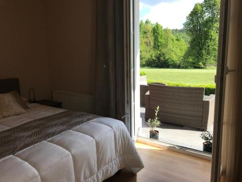 Schlafzimmer mit einem Bett und einer Tür zu einer Terrasse in der Unterkunft Linden Garden Apartment in Postojna