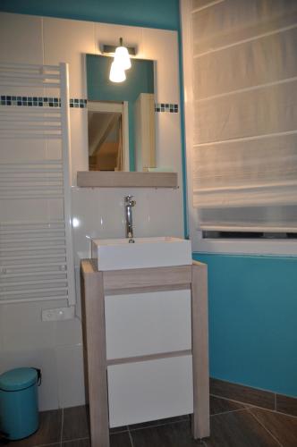 une salle de bain avec un lavabo et un miroir dans l'établissement Le Petit Neptune, à Versailles