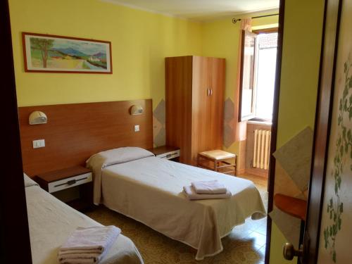um quarto de hotel com duas camas e uma janela em Albergo al Castello em Millesimo