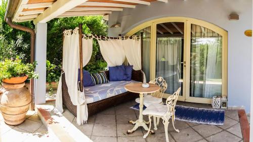 a porch with a bed and a table and chairs at Relais Villa Al Vento in Incisa in Valdarno