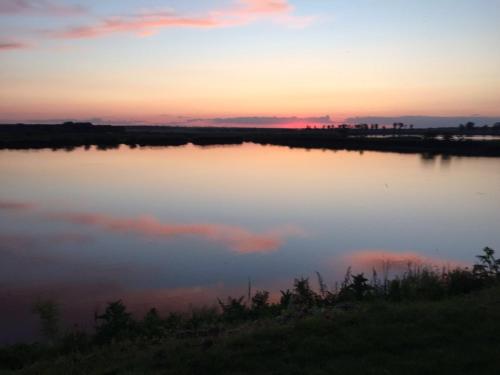 a view of a lake at sunset at Hanul Cocosul in Vităneşti