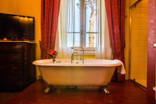 a bath tub in a bathroom with a window at Relais Villa Al Vento in Incisa in Valdarno