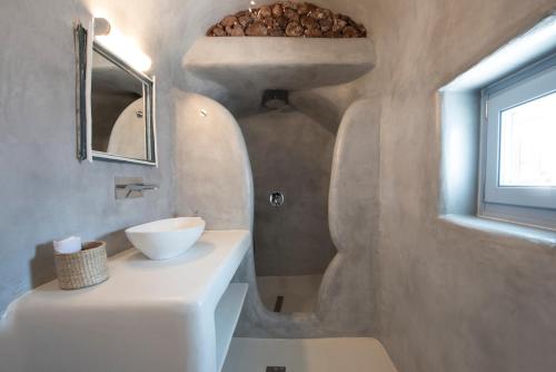 un bagno con un lavandino bianco e uno specchio di Red Stone Villa a Oia