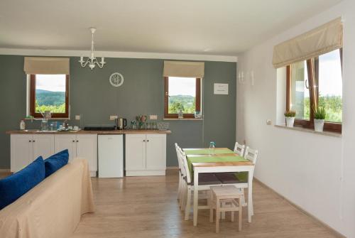 Apartamenty w Gorach Stolowych في شتشيتنا: مطبخ وغرفة معيشة مع طاولة وأريكة