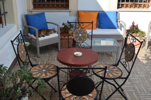 a cat laying on a chair on a patio at Alla Posta Guest House in Garna dʼAlpago