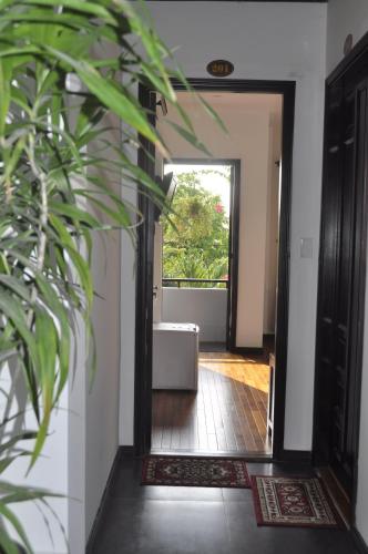 a hallway with a door leading into a room with a couch at Green CoCo HomeStay in Hoi An