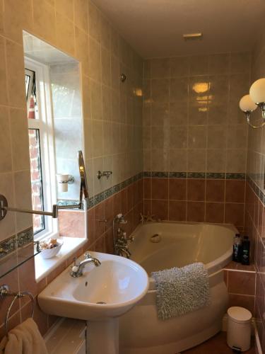 a bathroom with a tub and a sink and a toilet at Richmond Cottage in Chichester