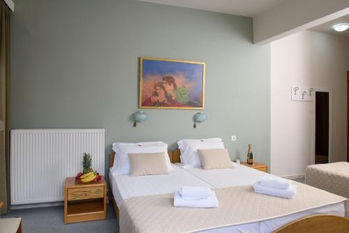 a bedroom with two beds and a painting on the wall at Hotel Europe in Paralia Katerinis