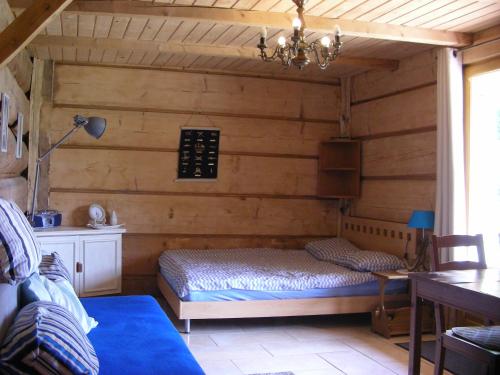 a bedroom with a bed in a room with wooden walls at Pod Kotem in Rowy
