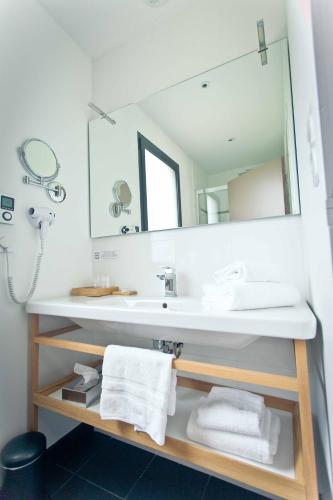 une salle de bain avec un lavabo et un miroir dans l'établissement Auberge de la Hardouinais-Arduen, à Saint-Launeuc