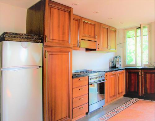 una cucina con armadi in legno e frigorifero bianco di Budget Romance Tower Studio a Lari