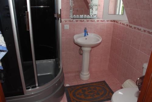 a pink bathroom with a sink and a shower at " У Татьяны" in Cholpon-Ata