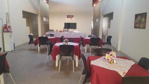 uma sala de jantar com mesas e cadeiras vermelhas e pretas em Pousada Portal do Cariri em Juazeiro do Norte