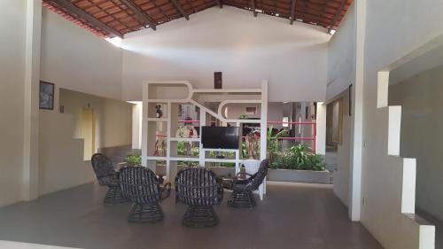 Pousada Portal do Cariri في خوازيرو دو نورتي: غرفة معيشة مع كراسي وطاولة وتلفزيون