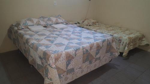 Una cama con edredón en una habitación en Pousada Portal do Cariri en Juazeiro do Norte