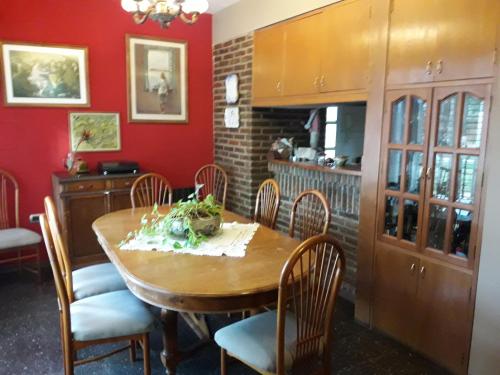 uma sala de jantar com uma mesa de madeira e cadeiras em Chalet de las Tejas em Rosário