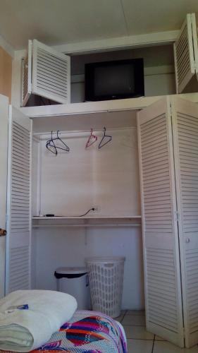 a bedroom with white closets with red glasses on the wall at Don Santiago Guesthouse Downtown in San Ignacio