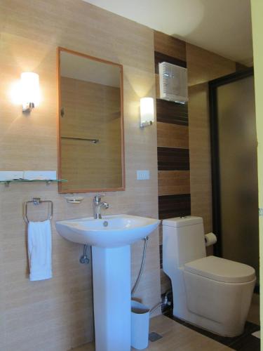 a bathroom with a sink and a toilet at Tugawe Cove Resort in Colongcocon