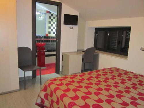 a bedroom with a bed and a desk and a window at La Cartolina del Sannio in Campolattaro