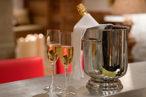 three glasses of wine sitting on a table at Hotel Berghof in Zermatt