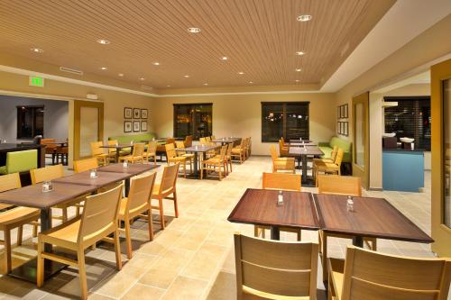 a restaurant with wooden tables and chairs at Country Inn & Suites by Radisson, Charlottesville-UVA, VA in Charlottesville