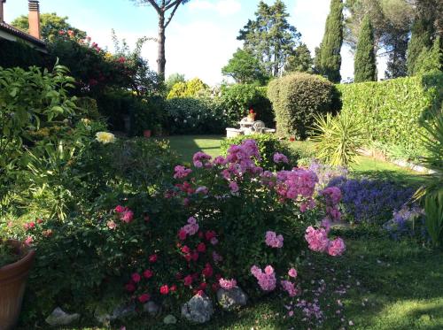 a garden with pink and purple flowers in a yard at Villa Nanda a 15 minuti da Roma piscina esclusiva , villa nella natura in Formello