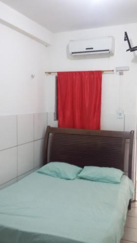 um quarto com uma cama com uma cortina vermelha em Hotel Italia em Timon