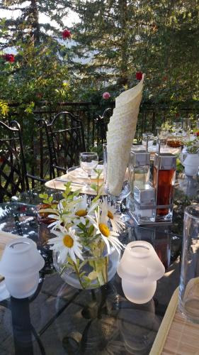 a glass table with flowers in a vase on it at Hotel Perfect in Yamna