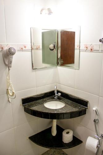 a bathroom with a sink and a mirror at Gamboa Eco Refugio Pousada in Iporanga