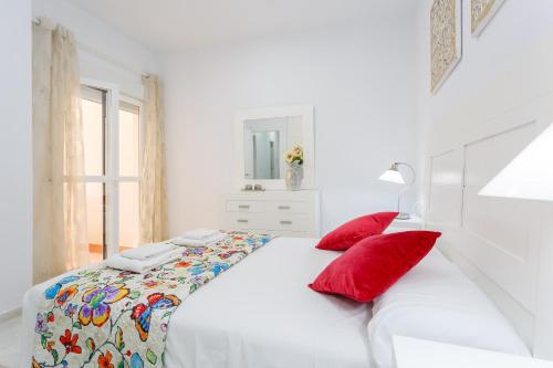カディスにあるCasa TANGUILLOS de Cadizの白いベッドルーム(赤い枕の白いベッド1台付)