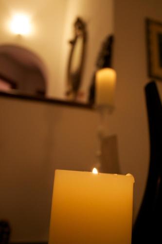 a yellow candle in a room with a mirror at La Villetta in Pula