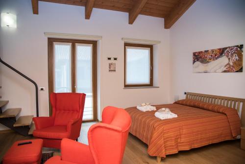 Sanfront的住宿－Resort Monviso，一间卧室配有一张床和两张红色椅子