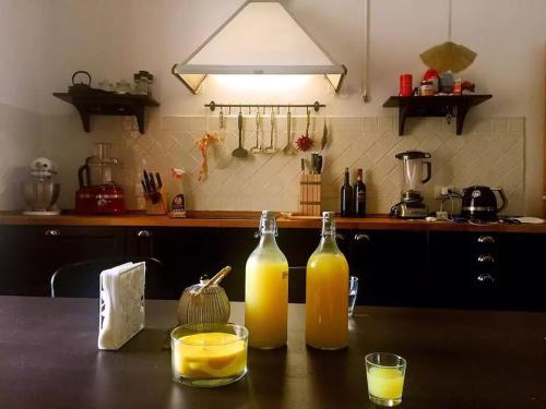 two bottles of orange juice and two glasses on a table at Cadorna in Florence
