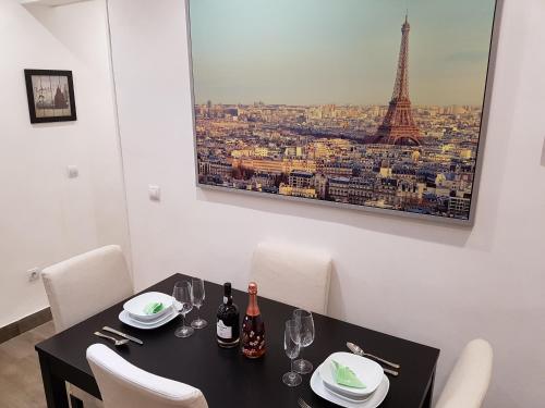 un comedor con una mesa con copas de vino y la torre Eiffel en Apartment Meson de Paredes, en Madrid