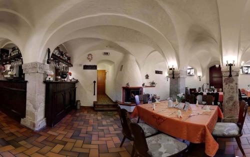 ein Restaurant mit einem Tisch und Stühlen in einem Zimmer in der Unterkunft Hotel Folklorehof in Chemnitz