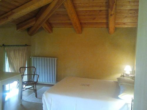 1 dormitorio con cama blanca y techo de madera en Locanda San Lorenzo, en Roddino