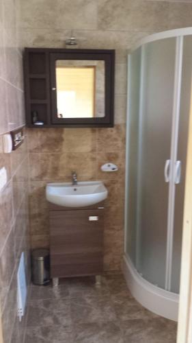 a bathroom with a sink and a mirror at Domki na Różanej 2 in Rowy